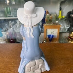 Figura de mujer sentada con gorro porcelana NAO LLADRO Spain